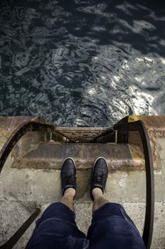 Feet on the water's edge, detail of exploration and contemplation