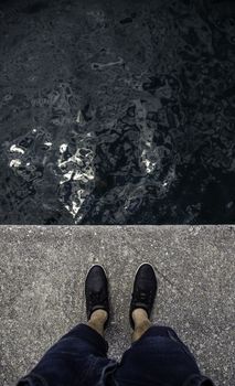 Feet on the water's edge, detail of exploration and contemplation