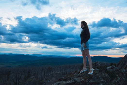 Travel, lesure and freedom concept - woman on the top of Altai mountain, beauty summer evening landcape