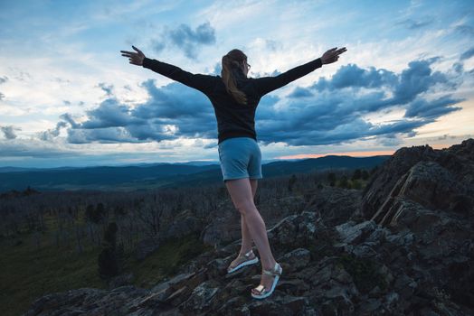 Travel, lesure and freedom concept - woman on the top of Altai mountain, beauty summer evening landcape