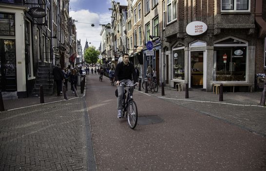 Bicycles in Amsterdam, people cycling, tourism in Europe