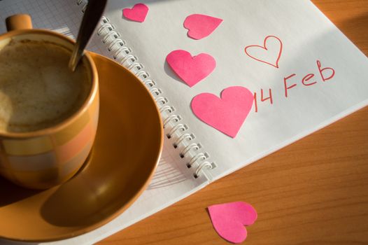 Preparation for Valentine's Day: the notebook and hearts, Cup of coffee, close-up.