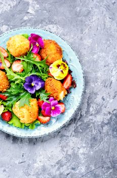 Vitamin summer salad with strawberries, grilled cheese, arugula and flowers.Healthy food