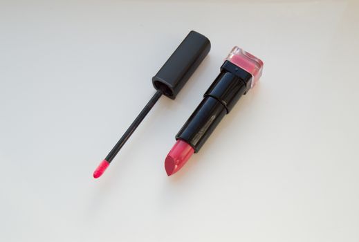 brush for lipgloss, lipstick red, pink on white background.