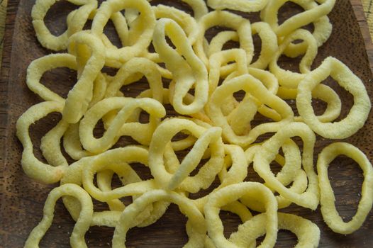 Onion rings on a dark wooden dish background, close-up, top view