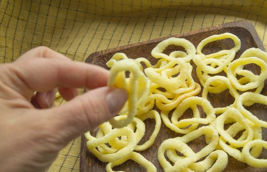 women's hand holding mouthwatering fried onion rings chips.