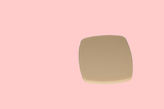 Cosmetic puff for makeup isolated on pink background, top view.