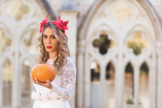 Portrait of fairy tale queen holding a pumpkin