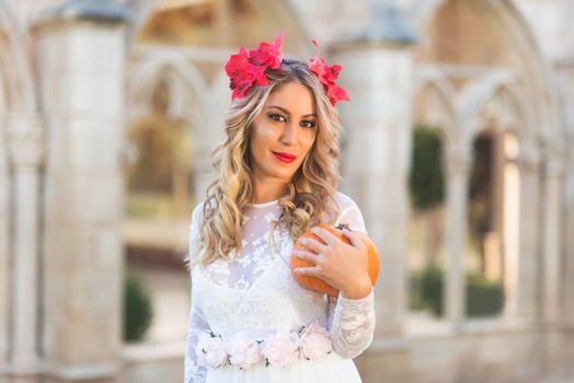 Portrait of fairy tale queen holding a pumpkin