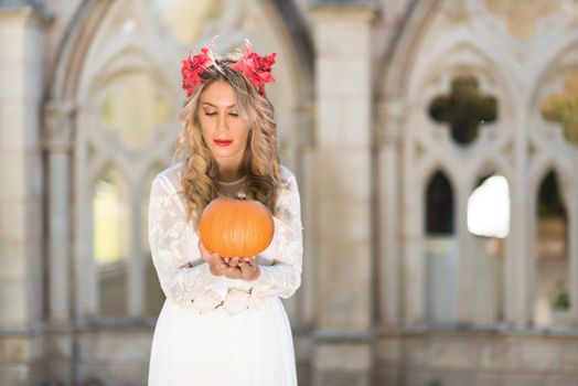 Portrait of fairy tale queen holding a pumpkin