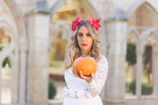 Portrait of fairy tale queen holding a pumpkin