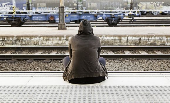 Woman sitting in a train station, detail waiting to grab a train
