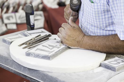 Person carving stone, detail of a manual and craft work