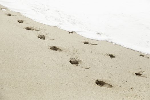 Footprints in the sand beach, detail marks at sea