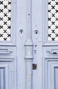 Old decorated door in blue, detail of urban decoration, protection