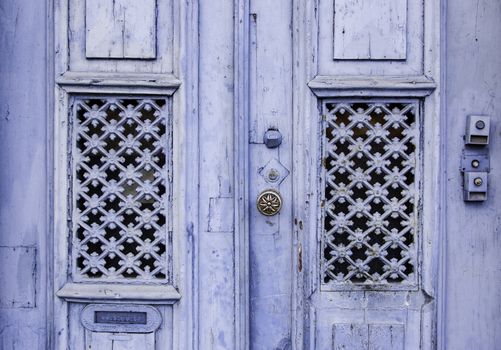 Old decorated door in blue, detail of urban decoration, protection