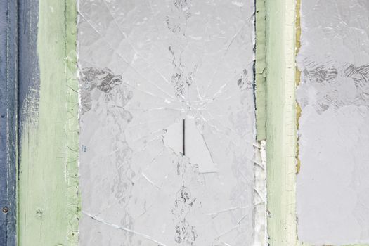 Broken glass window in urban building, vandalism