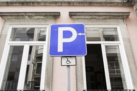 Handicapped parking sign in urban street, symbol