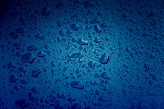 Rain drops, detail of a wet blue background, cold and texture