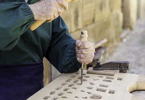 Man carving wood, detail of a traditional craft, creation