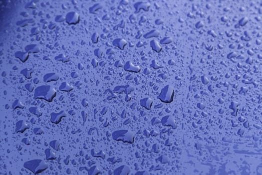 Rain drops, detail of a wet blue background, cold and texture