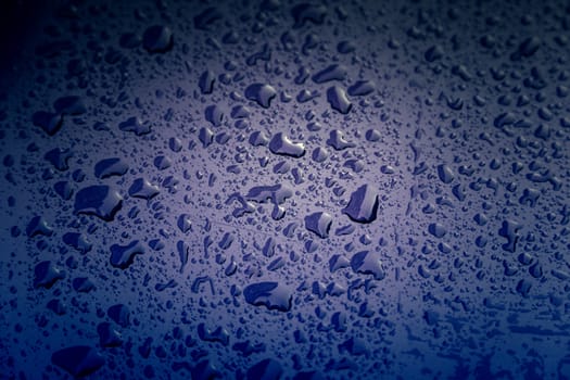 Rain drops, detail of a wet blue background, cold and texture