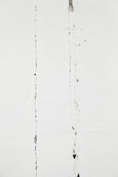White wall with cracks, detail of a deteriorated wall, textured background