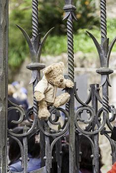 Teddy bear on a fence, detail of a gift and an omenaje, tragedy