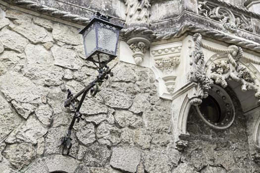 Old street lamp on a wall, detail of city lighting, electricity and light