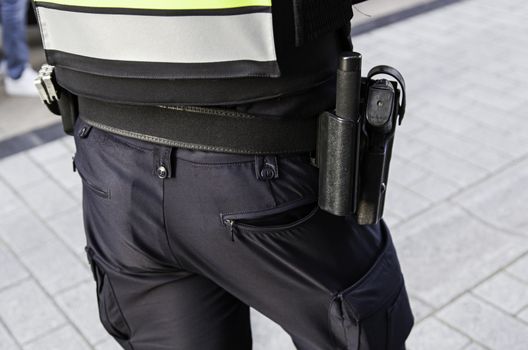 Police in the city, detail of a security guard, pistol and handcuffs