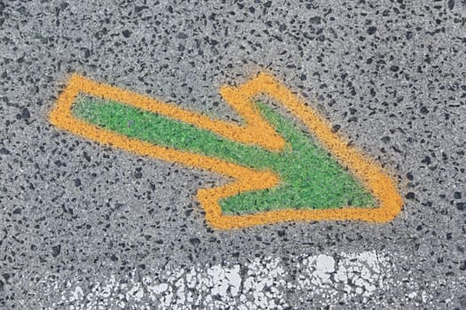 Arrow painted on the asphalt, detail of information and indication, road safety