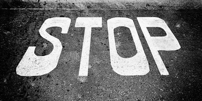 Stop sign on asphalt, detail of a traffic signal, security and prohibition