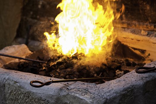 Carbon fire in a forge, detail of a workshop with iron