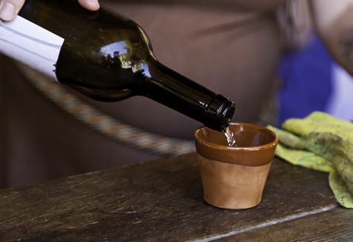 Serving wine in a clay cup, detail of a bar, alcohol and beverage service