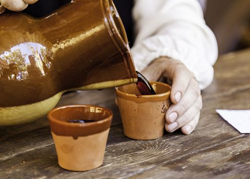 Serving wine in a clay cup, detail of a bar, alcohol and beverage service