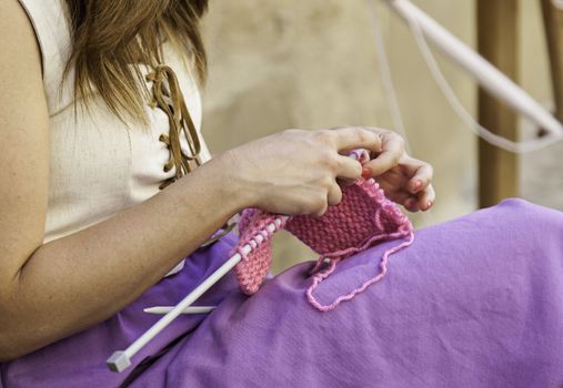 Young woman knitting clothes wool, detail of old tradition to make clothes