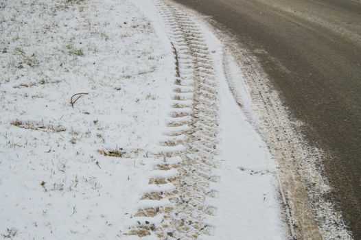 Abstract winter background on snow, close-up of the track from the car tire tread.