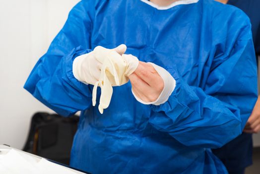 Nurse putting on surgical gloves