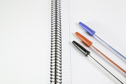 Three basic color pens on a notebook, detail of school for the education, space for text