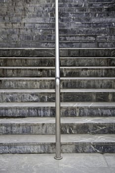 Marble staircase, detail of stairs in the city with a shiny metal railing, urban detail