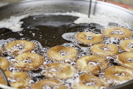 Frying donuts in a market, detail of a kitchen, sweet dessert