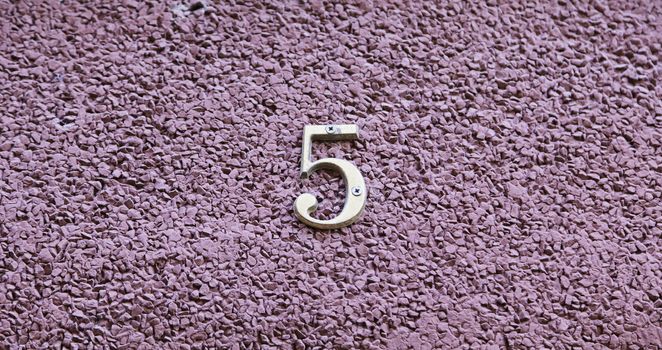 Number five on the wall of a house, detail of a number of information, odd number
