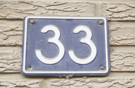 Number thirty-three on the wall of the house, detail of a number of information, odd number