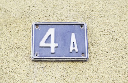 Number four on the wall of a house, detail of a number of information, even number