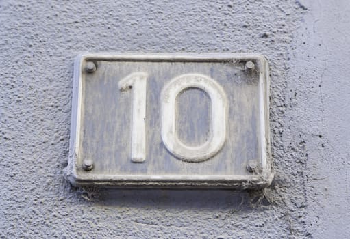 Number ten on the wall of a house, detail of a number of information, even number
