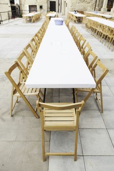 Table with many chairs, detail of a table to eat on the street
