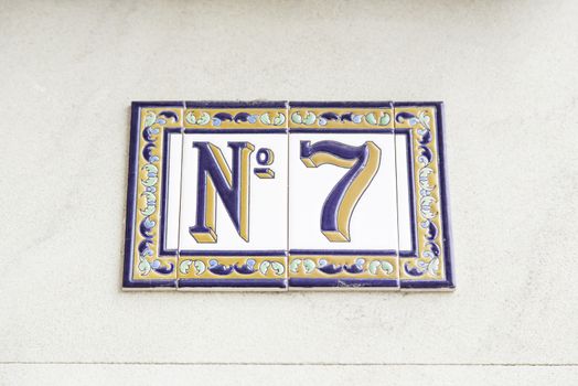 Number seven on the wall of a house, detail of a number of information, odd number