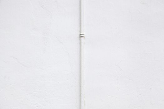 White wall with pipe, detail of a facade