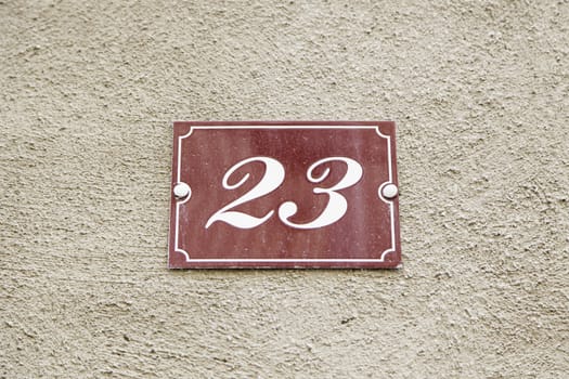 Number twenty-three on the wall of a house, detail of a number of information, odd number