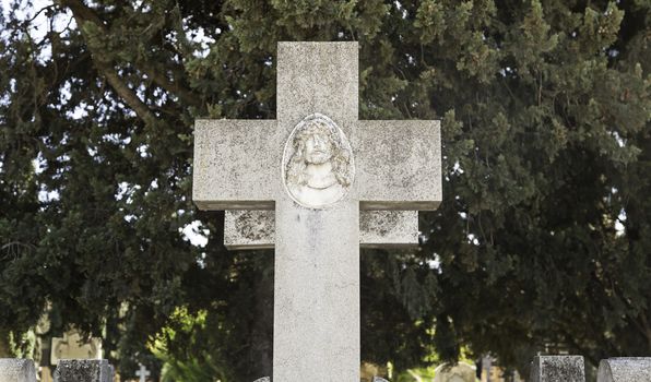 Religious cross on a grave, detail of an old cross in a cemetery